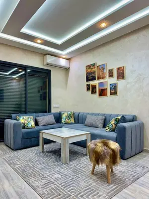 a living room with a blue couch and a coffee table at Cozy Apt Near Marrakech Airport in Marrakech
