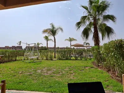 a park with a swing and palm trees at appartement- Marrakech-Sapphire in Marrakech