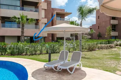 two chairs and an umbrella in front of a building at appartement- Marrakech-Sapphire in Marrakech