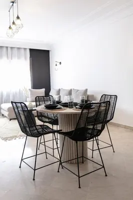 a dining table and chairs in a living room at Place To Be Marrakech Downtown in Marrakech