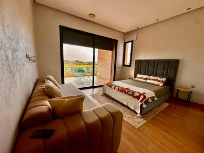 a bedroom with a bed and a couch at Villa ARGANA 6 chambres avec piscine jacuzzi et hammam à Argan Golf 10 min du centre in Marrakech