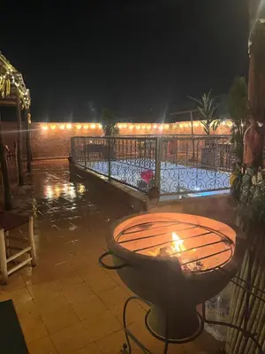 a table with a candle on a patio at night at Red Vibes Hostel Marrakech in Marrakech