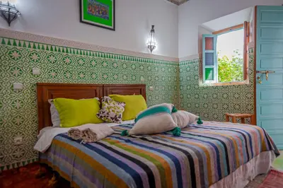 a bedroom with a bed with yellow and green wallpaper at Riad Dar Mamouni in Marrakech