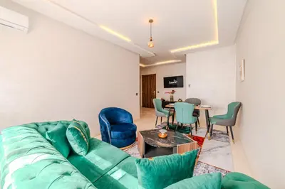 a living room with a couch and chairs and a table at 2BR Modern Apt 2min M Avenue Balcony Fiber WiFi 2 Pools 24 7 Security Hivernage in Marrakech