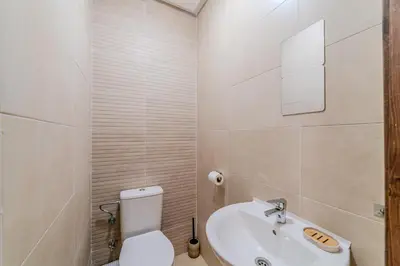 a white bathroom with a toilet and a sink at 2BR Modern Apt 2min M Avenue Balcony Fiber WiFi 2 Pools 24 7 Security Hivernage in Marrakech