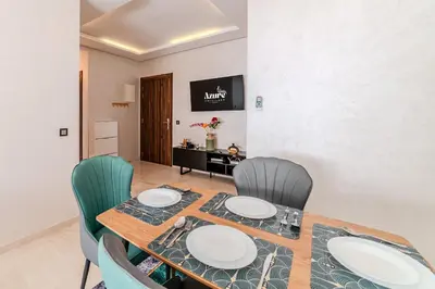a dining room with a table and chairs at 2BR Modern Apt 2min M Avenue Balcony Fiber WiFi 2 Pools 24 7 Security Hivernage in Marrakech