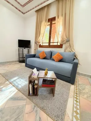 a living room with a blue couch and a table at VILLA 34 - 4 Masters, Moroccan Charm & Modern Comfort with Private Pool in Marrakech
