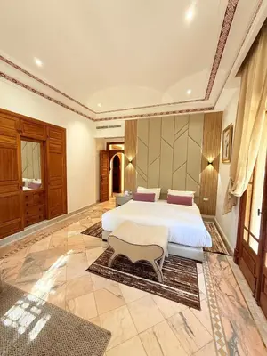 a large bedroom with two beds and a table at VILLA 34 - 4 Masters, Moroccan Charm & Modern Comfort with Private Pool in Marrakech
