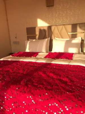 a bed with red flowers on top of it at Quad Alia Marrakech in Marrakech