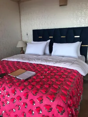 a bed with a red blanket with a laptop on it at Quad Alia Marrakech in Marrakech