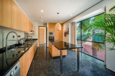 a kitchen with wooden cabinets and a large window at Sublime Villa Neuve Marrakech - Piscine Chauffée in Marrakech