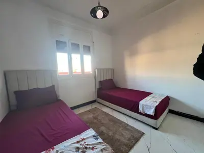 a bedroom with two beds and a window at Résidence zitouna in Marrakech