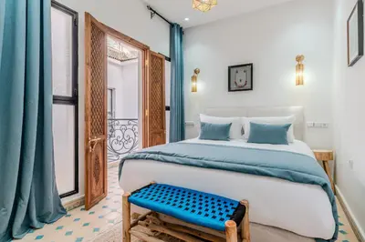 a bedroom with a bed and a blue bench at Riad Dar Amarena Exclusif BreakFast in Marrakech