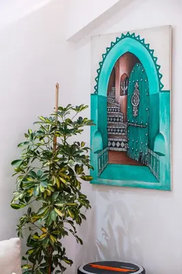 a painting of a door on a wall next to a plant at Riad Dar Amarena Exclusif BreakFast in Marrakech