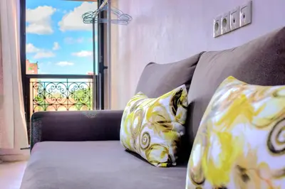 a couch with two pillows in front of a window at Residence Jnan atlas gueliz in Marrakech