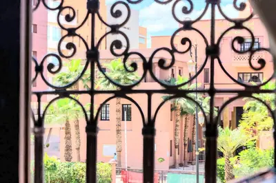 an iron gate with a view of a building at Residence Jnan atlas gueliz in Marrakech