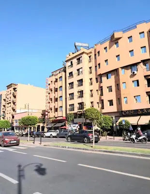 a city street with cars parked in front of buildings at Residence Jnan atlas gueliz in Marrakech