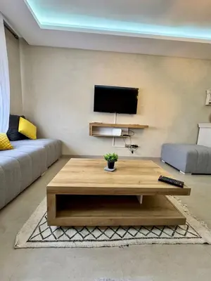 a living room with a coffee table and a tv at Charming appartement 1 bed in Guéliz in Marrakech