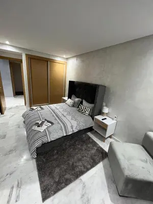 a bedroom with a large bed and a table at Superbe appartement T2 plein centre de Marrakech in Marrakech