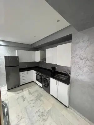 a kitchen with white cabinets and a washer at Superbe appartement T2 plein centre de Marrakech in Marrakech