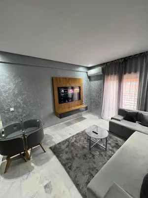 a living room with a couch and a tv at Superbe appartement T2 plein centre de Marrakech in Marrakech