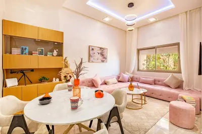 a living room with a pink couch and a table at Stylish Cozy Appartement in marrakech with Pool in Marrakech