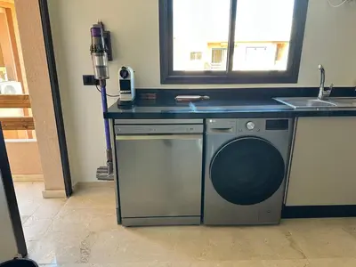 a kitchen with a washing machine and a sink at Prestige cocon in Marrakech