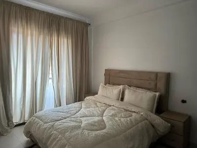 a bedroom with a bed and a large window at appartement Lamrani in Marrakech