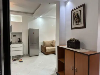 a kitchen with a refrigerator and a couch in a room at appartement Lamrani in Marrakech