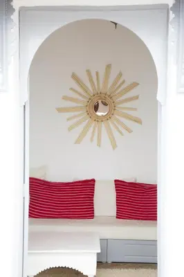 a mirror above a bed in a room at Riad Dar Wildeve in Marrakech