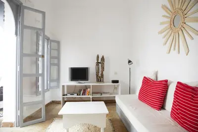 a living room with a white couch and red pillows at Riad Dar Wildeve in Marrakech