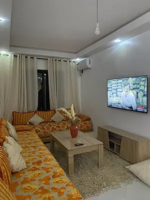 a living room with a couch and a tv on the wall at appartement Meryam in Marrakech