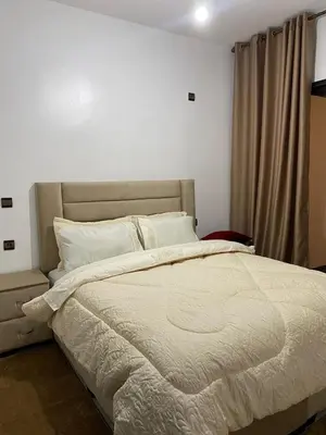 a bedroom with a large bed with white blankets and pillows at appartement Meryam in Marrakech