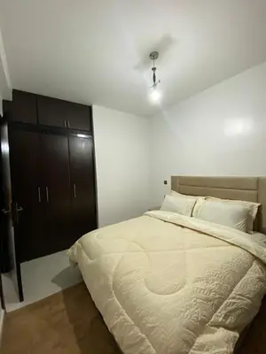 a bedroom with a large bed and a black cabinet at appartement Meryam in Marrakech