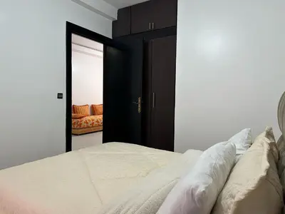 a bedroom with a bed and a couch in the background at appartement Meryam in Marrakech