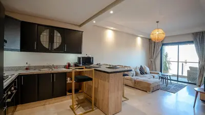 a kitchen and a living room with a couch at Grand T2, terrasse au coeur de Gueliz in Marrakech