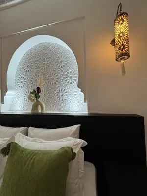 a bedroom with a bed with a white headboard and a lamp at Traditional Moroccan Flat in Palmeraie in Marrakech