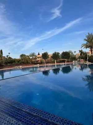 a large pool with blue water in a resort at Traditional Moroccan Flat in Palmeraie in Marrakech