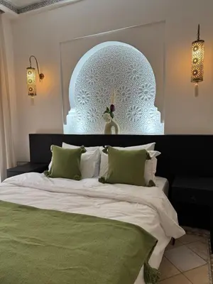 a bedroom with a large bed with a large headboard at Traditional Moroccan Flat in Palmeraie in Marrakech