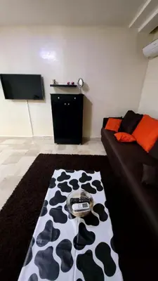 a living room with a black and white cow rug at Le Marrakchi 37 au coeur de l'hivernage pour les familles acte de mariage obligatoire in Marrakech
