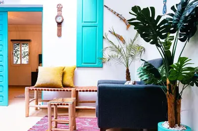 a living room with a blue couch and plants at Luxury Riad, Marrakech, Pool, Free Airport Shuttle, Dar Bassidi in Marrakech