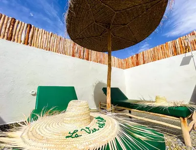 a straw hat and a chair and an umbrella at Luxury Riad, Marrakech, Pool, Free Airport Shuttle, Dar Bassidi in Marrakech