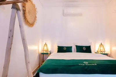 a bedroom with a bed with green sheets and a tripod at Luxury Riad, Marrakech, Pool, Free Airport Shuttle, Dar Bassidi in Marrakech