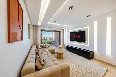a living room with a couch and a tv at Luxury Saphir- Golf, piscines & calme in Marrakech