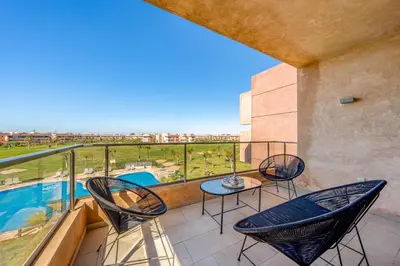 a balcony with chairs and a table and a pool at Luxury Saphir- Golf, piscines & calme in Marrakech