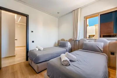 a bedroom with two beds and a window at Luxury Saphir- Golf, piscines & calme in Marrakech