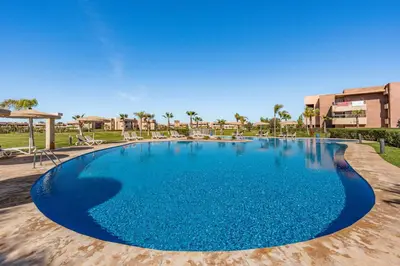 a large blue swimming pool in a resort at Luxury Saphir- Golf, piscines & calme in Marrakech