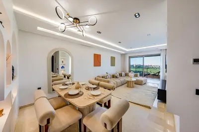 a living room with a table and chairs and a couch at Luxury Saphir- Golf, piscines & calme in Marrakech