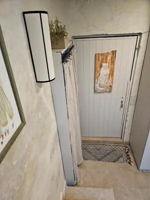 a hallway with a white garage door with a painting at Séjour au cœur de la medina in Marrakech