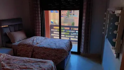 a hotel room with two beds and a window at Hivernage Cosy in Marrakech